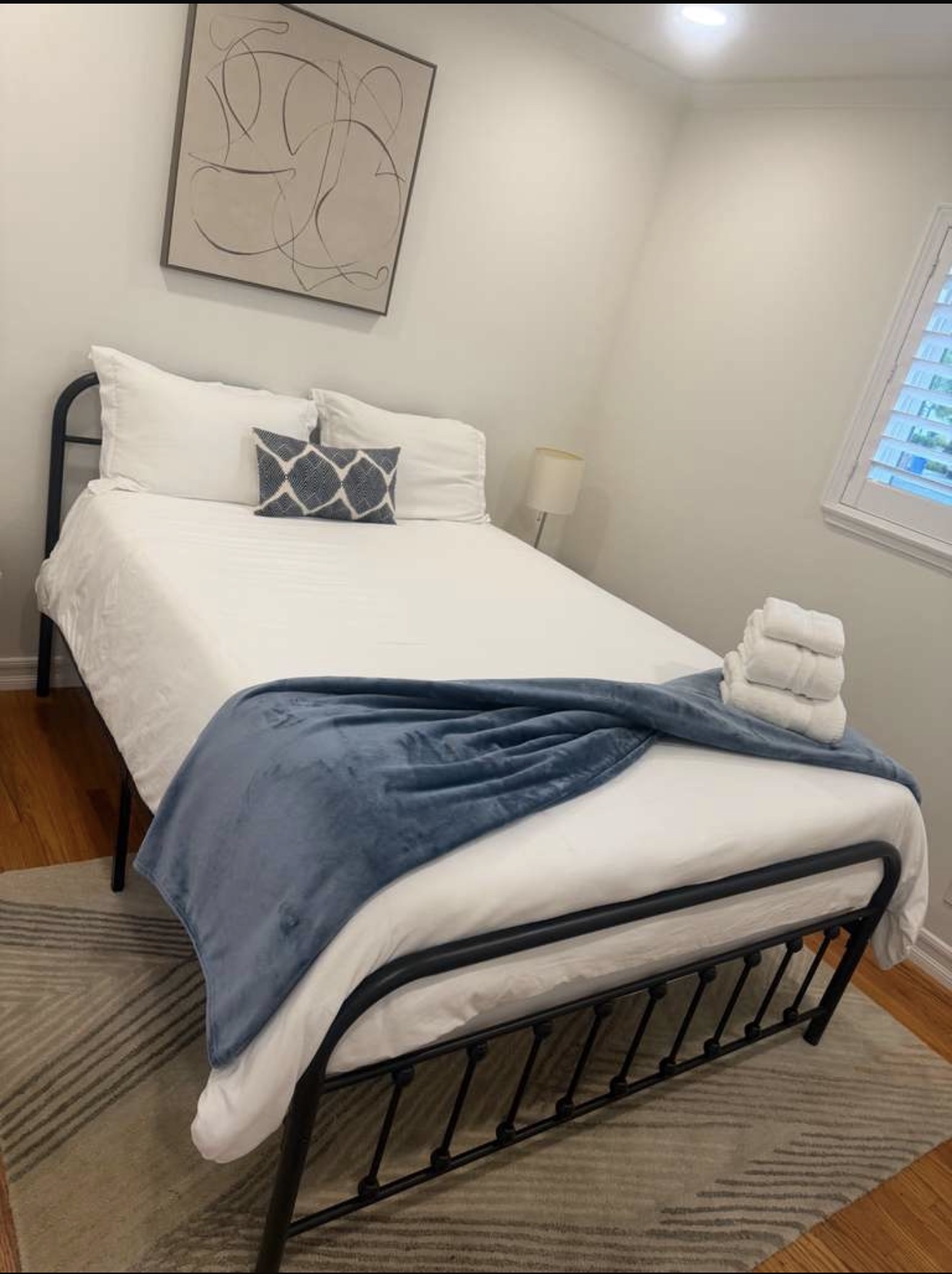 Guest bedroom freshly made with crisp linens and folded towels